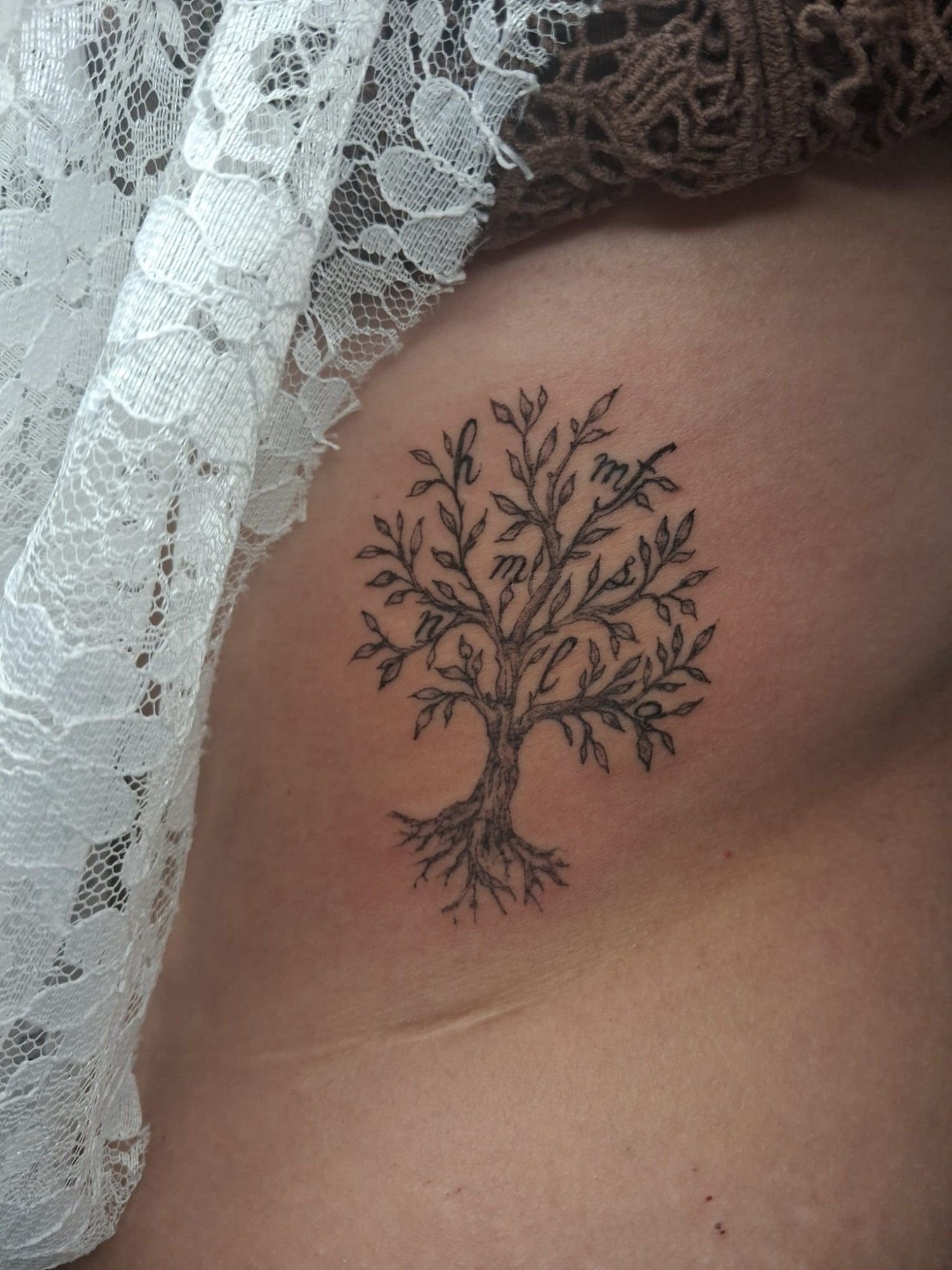 Arbre de vie aux branches feuillues et aux racines, en trait fin.