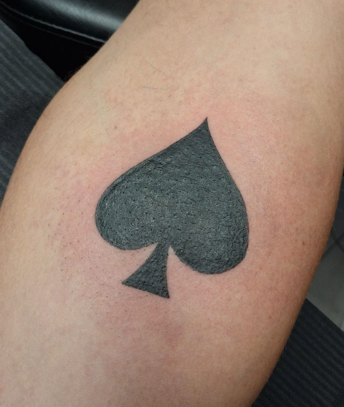 As de pique noir plein, tatoué à l’intérieur du bras.