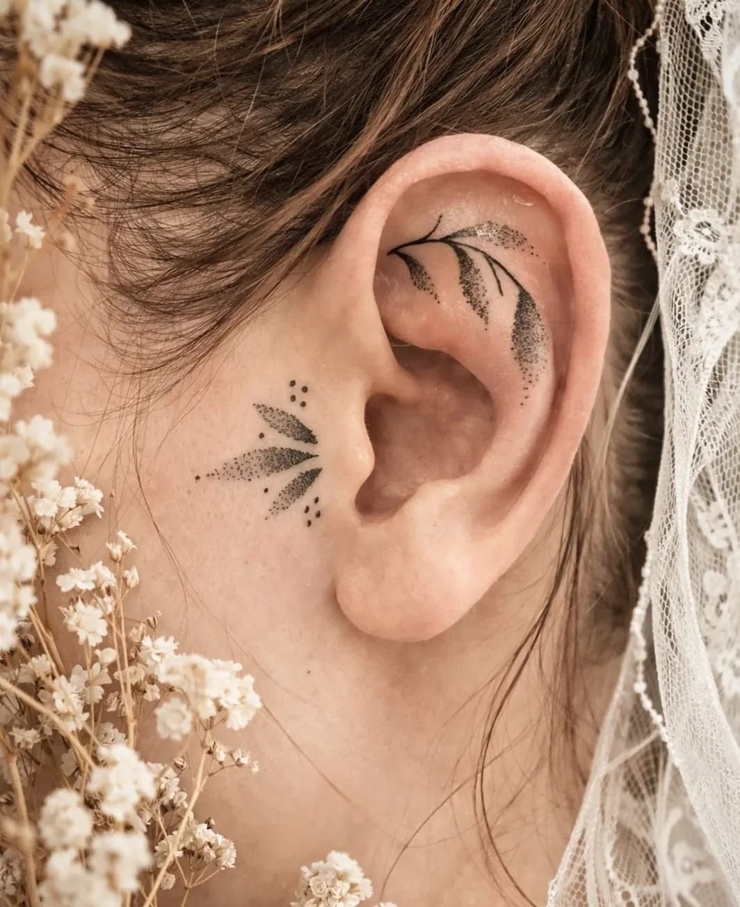 Branches de feuilles ombrées en points sur l’oreille et devant l’oreille, avec trois points.