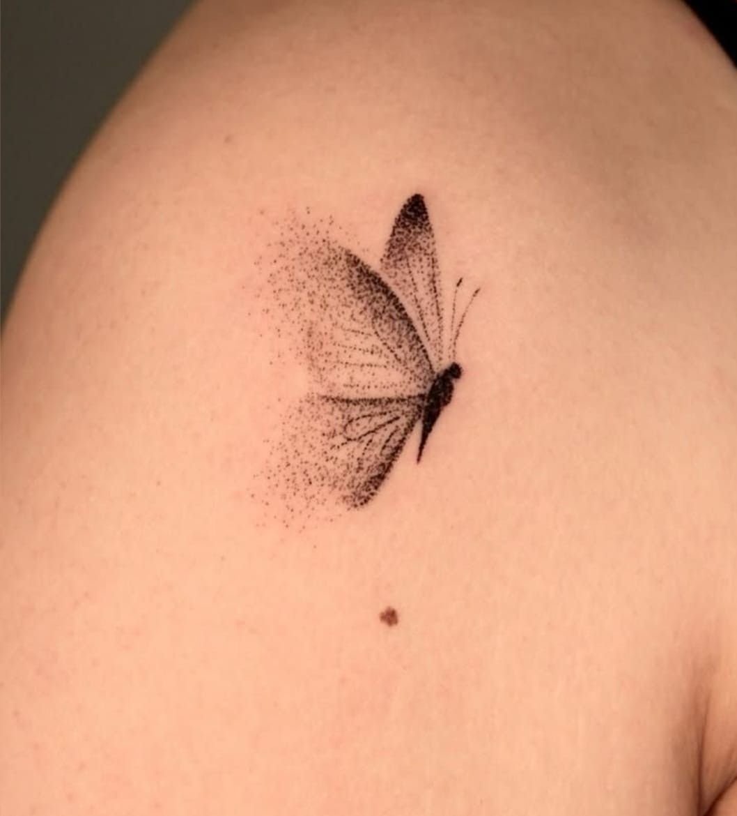 Papillon ombré en points, avec un nuage de points derrière ses ailes.