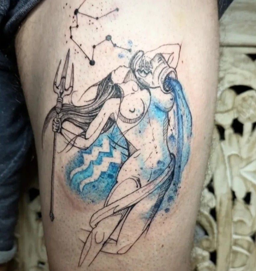 Femme du Verseau versant de l’eau, en trait fin, avec des taches d’aquarelle bleue, le symbole du Verseau et une constellation, sur la cuisse.